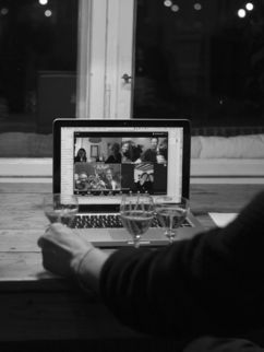 zwei Personen vor einem Laptop während einer Videokonferenz.