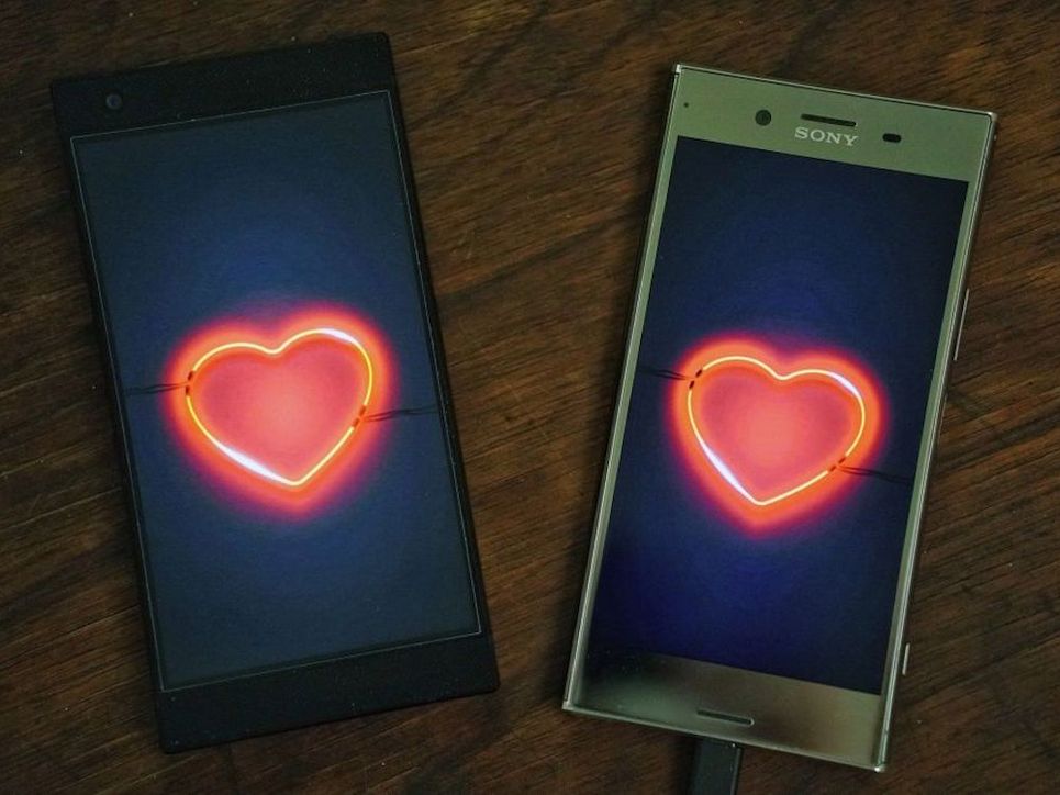 Zwei Smartphones mit leuchtenden Herzen auf dem Display.