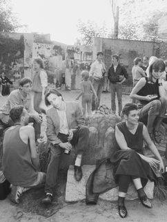 Schwarz-weiß Fotografie von vielen jungen Menschen auf einer Ostberliner Brachfläche zur Zeit des Mauerfalls.
