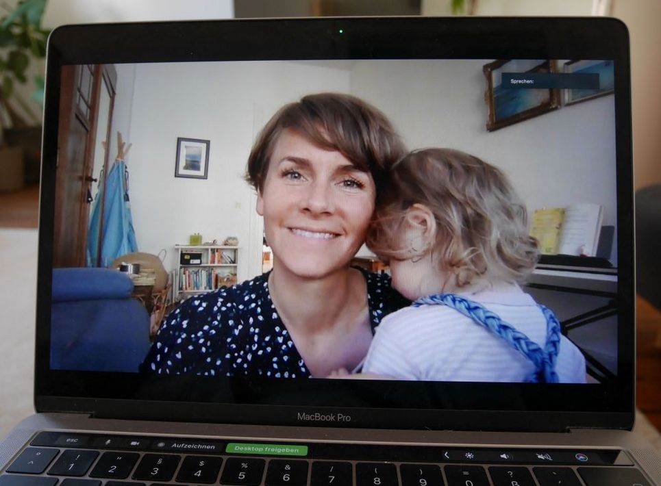 Janina Pawelz hat ihre kleine Tochter auf dem Arm und ist per Videokonferenz zugeschaltet