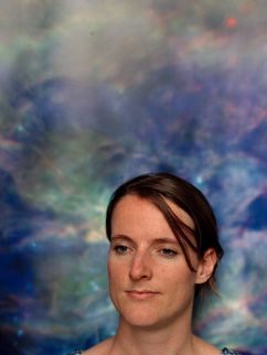 Porträt von Else Starkenburg vor einem bläulich-galaktischen Hintergrund.