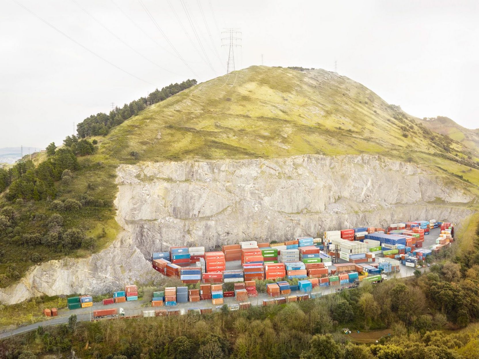 Container in der einer Einbuchtung eines Berges, die eventuell durch Bergbau entstanden ist.