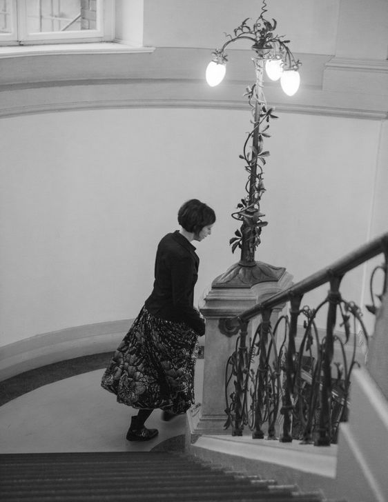 Jutta Allmendinger in einem Treppenhaus mit verziertem Geländer.