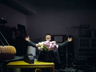 Wolfgang M. Heckl in einem dunklen Raum hinter einem erleuchteten Blumenstrauß.