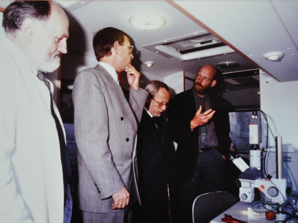 Vier Männer in einer Reihe im Labormobil.