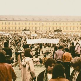 Menschenansammlung und Demonstration auf einem Platz in den 1970er Jahren.