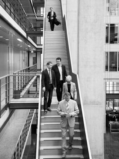5 Personen auf einer offenen Treppe in einem Gebäude.