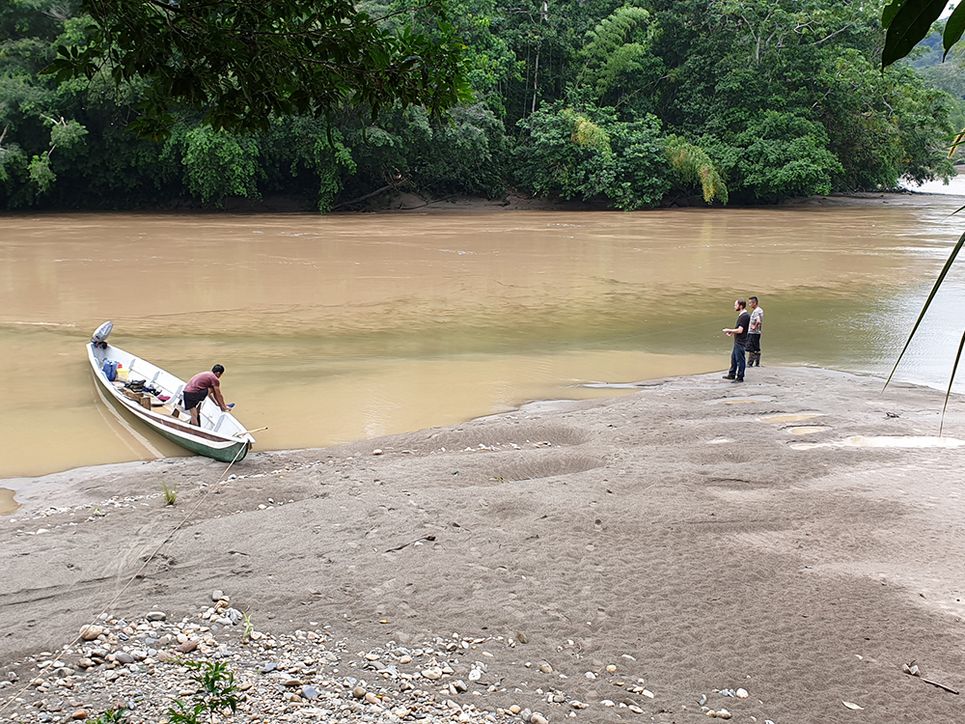 Auf einem Fluss im Regenwald erreichen zwei Forscher das Land auf einem Boot Ecuador 