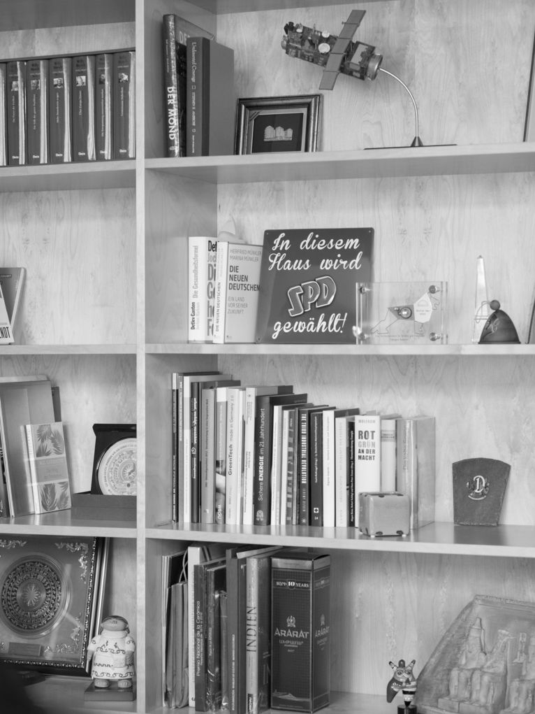 Ein Regal mit Büchern und anderen Dingen. Zentral ein Bild mit der Aufschrift: "In diesem Haus wird SPD gewählt."