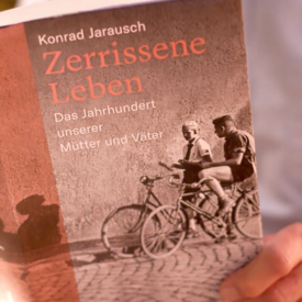 Buchcover "Zerrissene Leben" mit zwei Menschen auf Fahrrädern darauf.