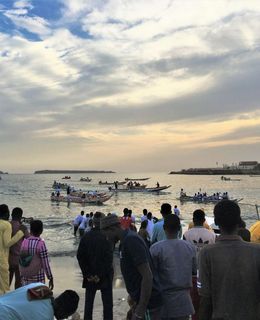 Zuschauer am Strand von Dakar beobachten ein Pirogenrennen, das in der Nähe des Fischmarkts der Stadt ausgetragen wird.