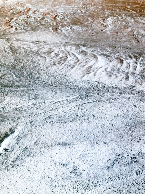 Luftbildaufnahme einer schneebedeckten, sandigen Landschaft