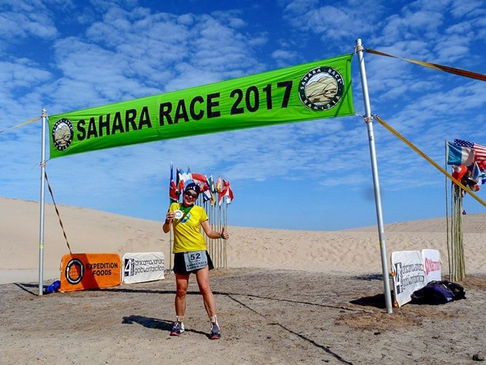 Andrea Löw mit Medaille am Ziel des Sahara Race 2017 in der Wüste.