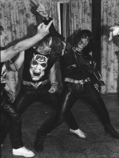 Junge Heavy-Metal-Fans in typischer Heavy-Metal-Kluft tanzen ekstatisch in einem Jugendklub.