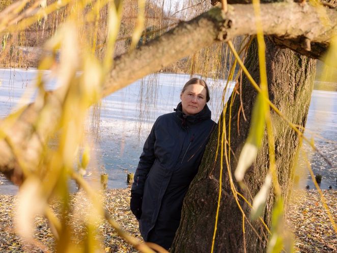 Die Ökonomin Maja Adena lehnt an einer Weide am Ufer der zugefrorenen Spreee.