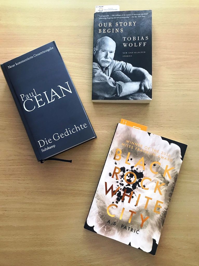 Drei Bücher auf einem Tisch: "Die Gedichte" von Paul Celan, "Our Story begins" von Tobias Wolff und "Black Rock White City" von A. S. Patric.
