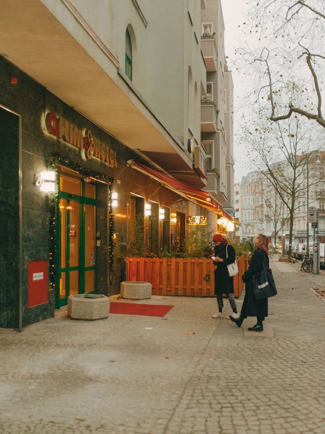 Annalisa Martin und Svenja Beller vor einem Hotel mit künstlicher Tannengirlande über dem Eingang.