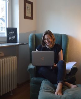 Louise Rokohl in einem Sessel mit Laptop.