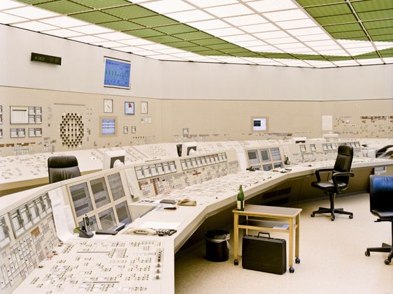 Rund geformter Büroraum mit Schaltpulten und Bildschirmen in einem Atomkraftwerk