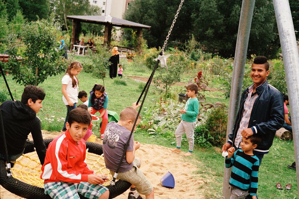 Kinder auf einer Schaukel im Garten.