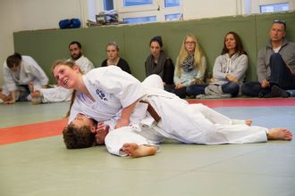 Mara Osswald im Zweikampf beim Jiu-Jitsu auf dem Boden einer Turnhalle.