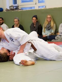 Mara Osswald im Zweikampf beim Jiu-Jitsu auf dem Boden einer Turnhalle.