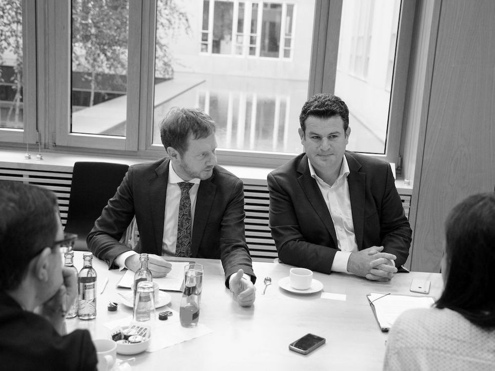 Michael Kretschmer und Hubertus Heil an einem Tisch mit Getränken im Gespräch.