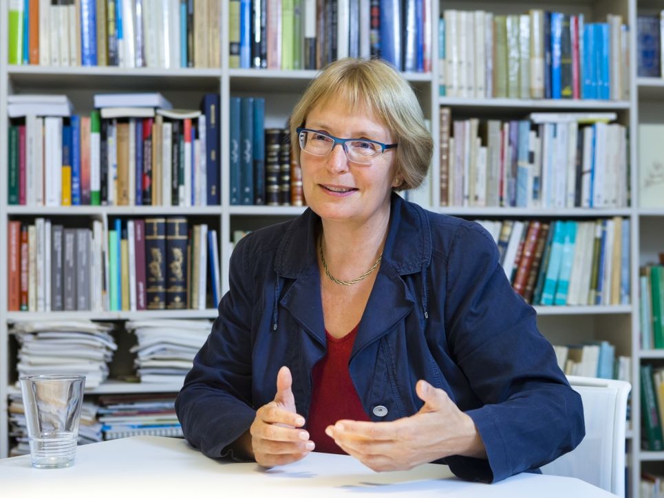 Ulrike Freitag vor einem Bücherregal.