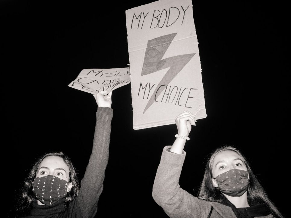 Zwei protestierende Frauen mit Gesichtsmasken halten Plakate aus Pappe in die Höhe. Auf einem ist die Aufschrift  »My body, my choice« - »Mein Körper, meine Wahl« zu lesen.