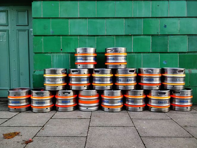 Bierfässer vor grüner Wand