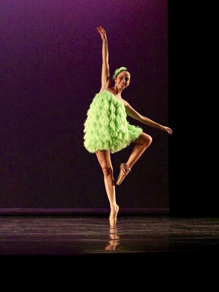 Marcela Prada in grünem Kostüm in Ballettpose auf einer Bühne.