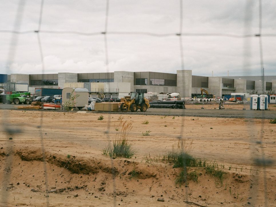 Blick durch einen Zaun auf die Gigafactory.