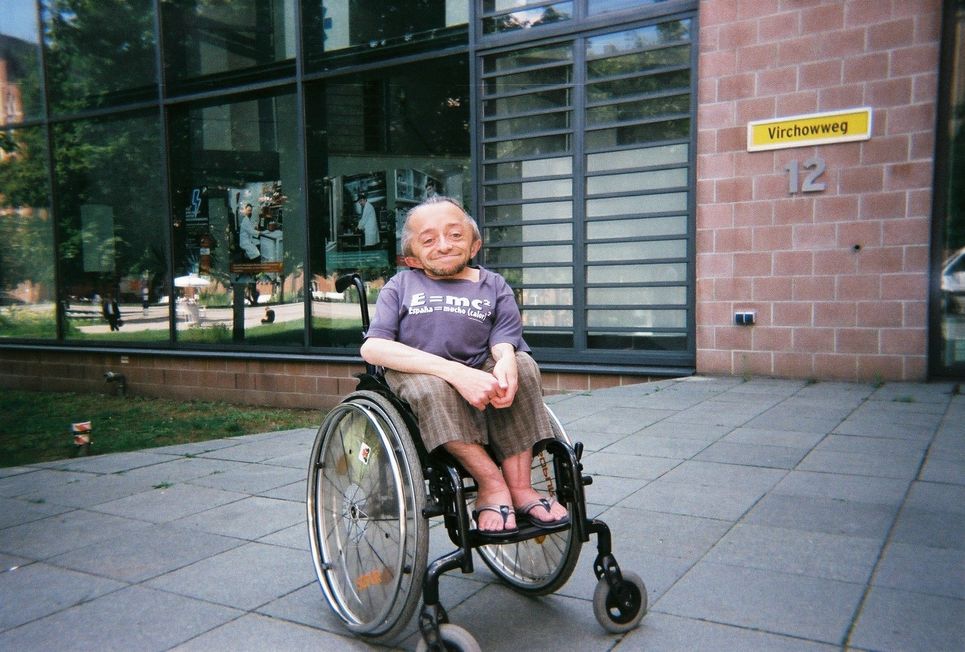Frederik Heinrich im Rollstuhl vor einem Gebäude.