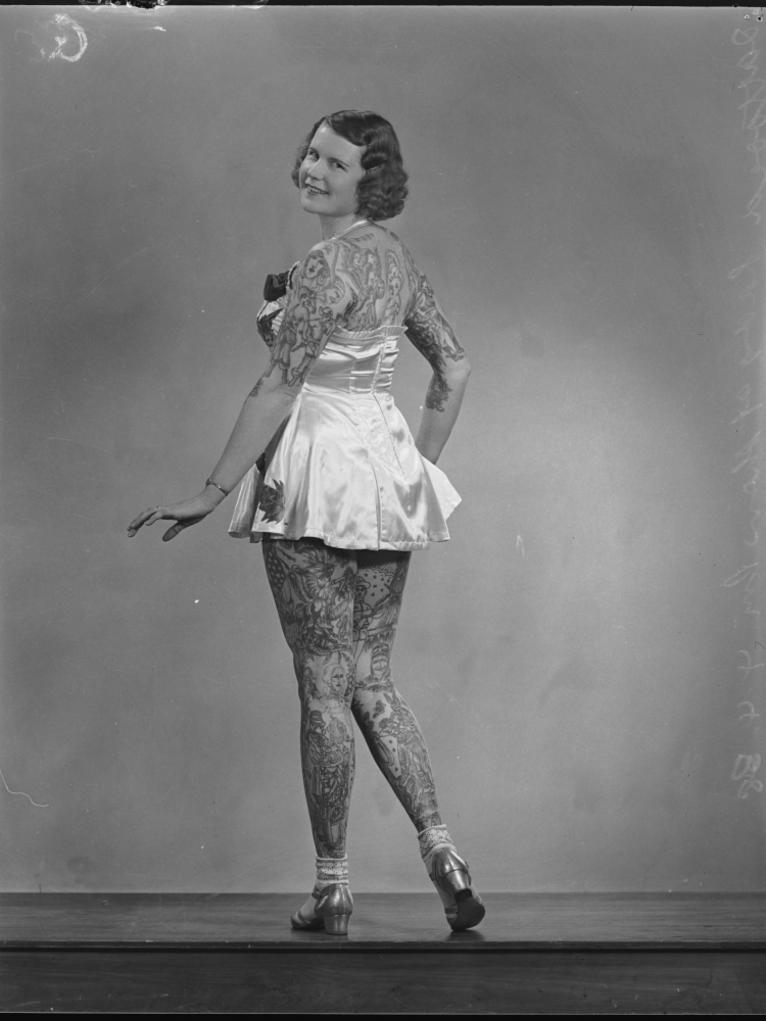 Lady Betty Broadbent im kurzen Kleidchen, den Blick rückwärts gewandt.