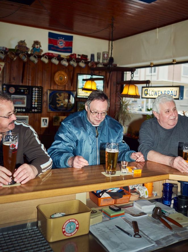 Drei Biertrinker in einer Kneipe.