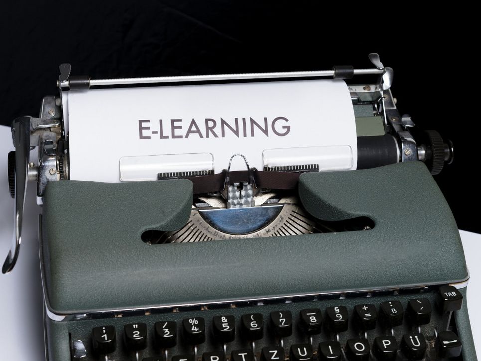 Alte Schreibmaschine, auf dem eingespannten Blatt ist »E-Learning« zu lesen. 