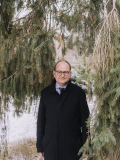 Porträt des Ökonomen Ottmar Edenhofer, umgeben von Tannengrün.