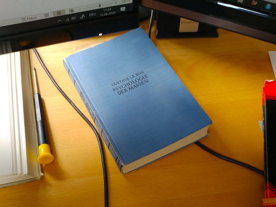 Buch mit dem Titel "Psychologie der Massen" auf dem Schreibtisch.