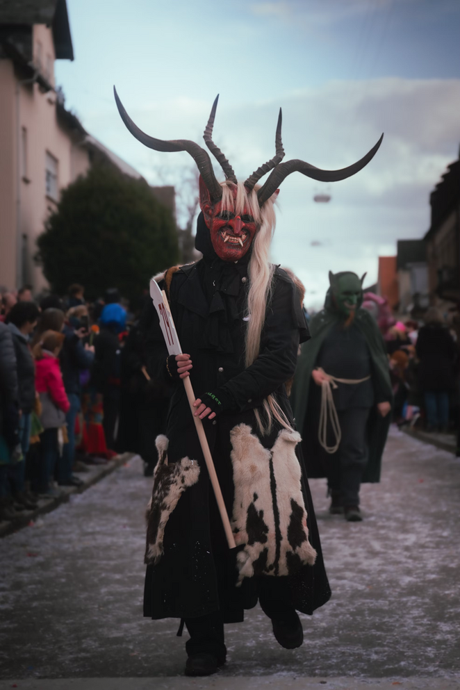 Person beim Karneval-Zug in Teufel Kostüm.