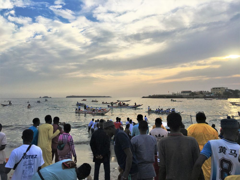 Zuschauer am Strand von Dakar beobachten ein Pirogenrennen, das in der Nähe des Fischmarkts der Stadt ausgetragen wird.