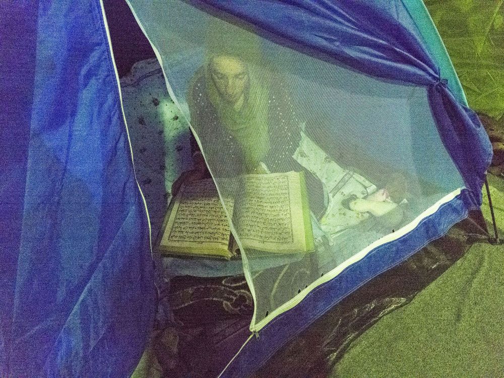 Eine lesende Junge Frau in einem Zelt.