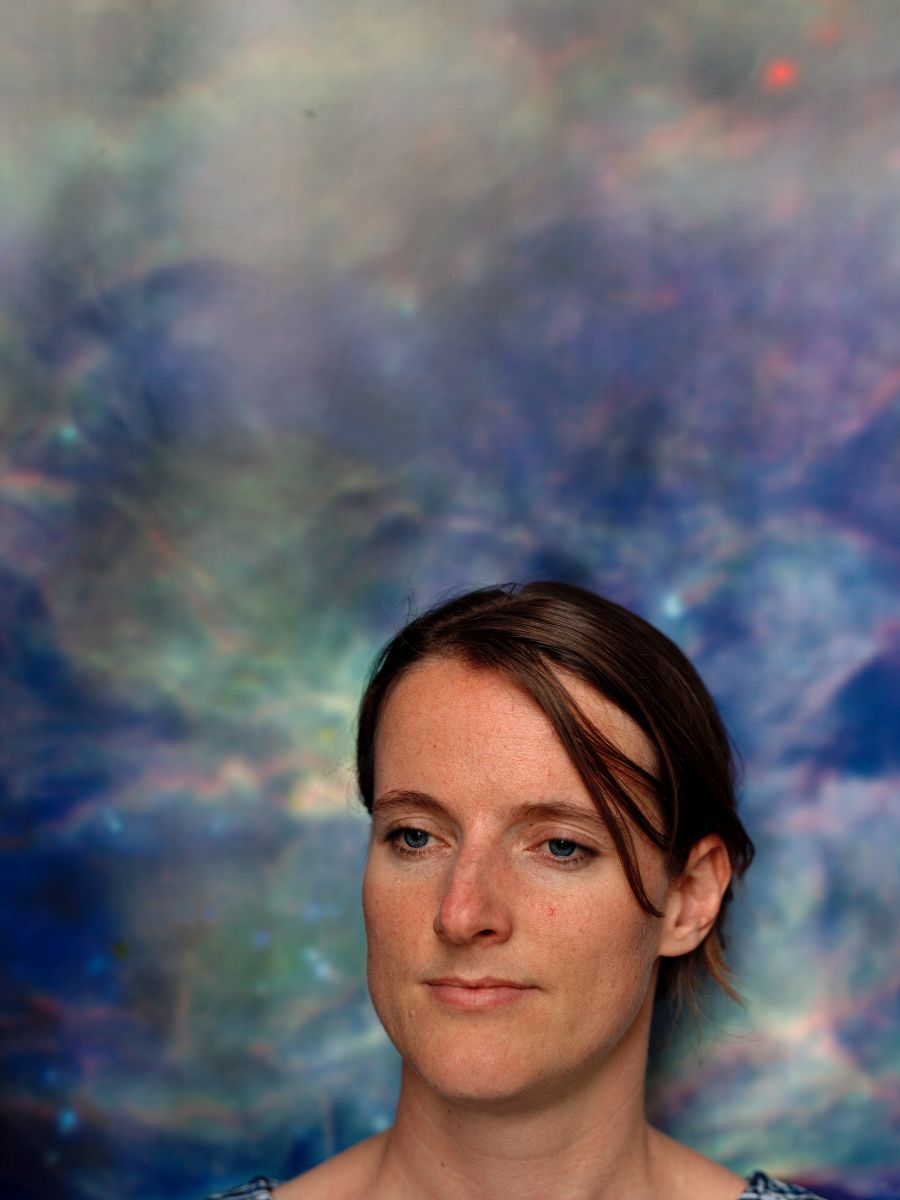 Porträt von Else Starkenburg vor einem bläulich-galaktischen Hintergrund.