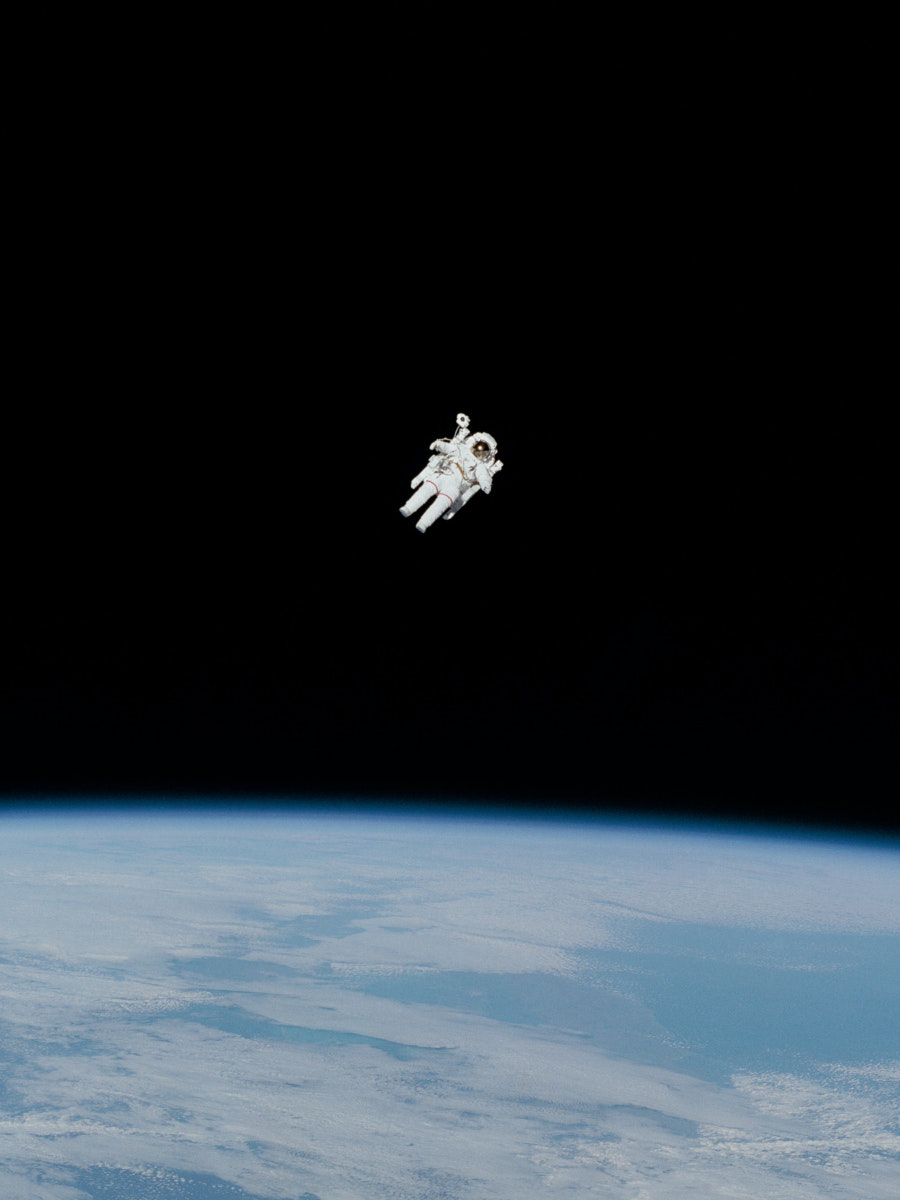 Astronaut schwebt im All über der Mondoberfläche.