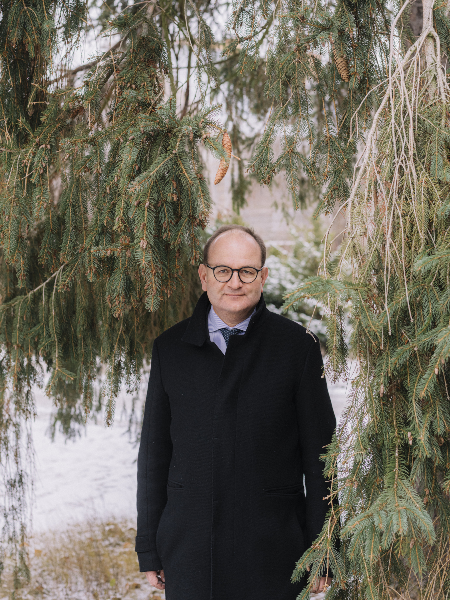 Porträt des Ökonomen Ottmar Edenhofer, umgeben von Tannengrün.