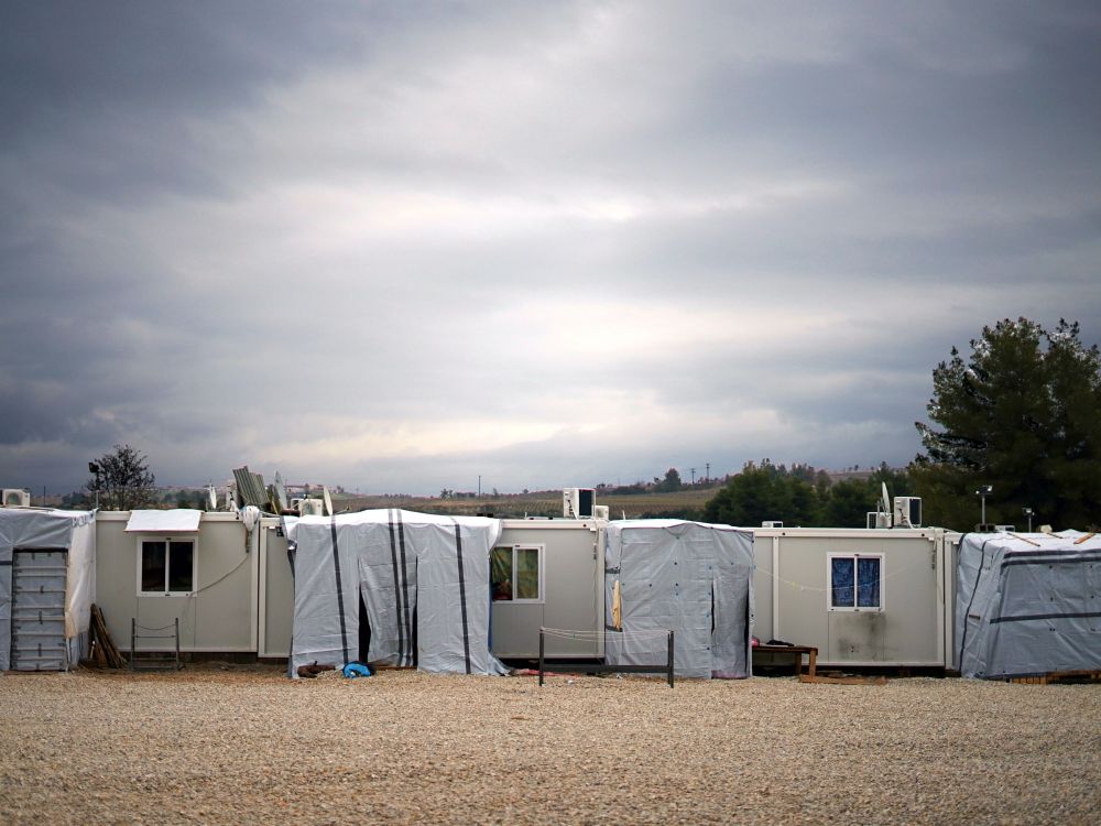 Weiße Wohncontainer einer Unterkunft für Geflüchtete, in ländlicher Umgebung